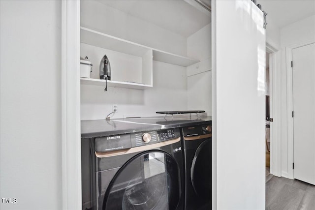 clothes washing area featuring dark hardwood / wood-style flooring and washer and dryer