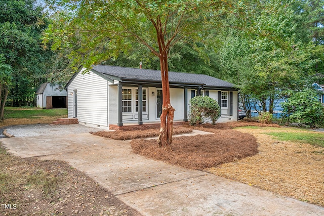 ranch-style home featuring a porch and a storage unit