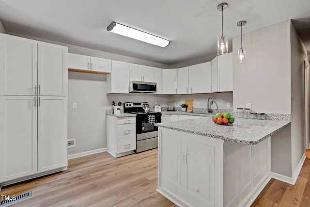 kitchen with light hardwood / wood-style flooring, hanging light fixtures, stainless steel appliances, light stone countertops, and white cabinetry