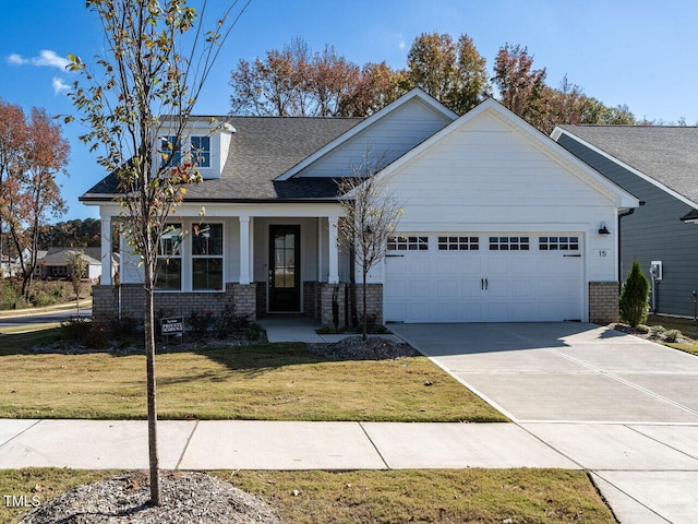 view of front facade featuring a porch, a front lawn, and a garage