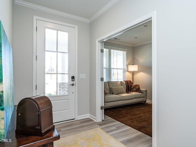 doorway with ornamental molding, a wealth of natural light, and light wood-type flooring