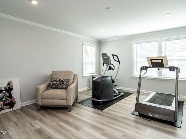 workout room with ornamental molding and light wood-type flooring