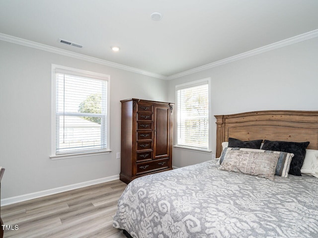 bedroom with light hardwood / wood-style floors and crown molding