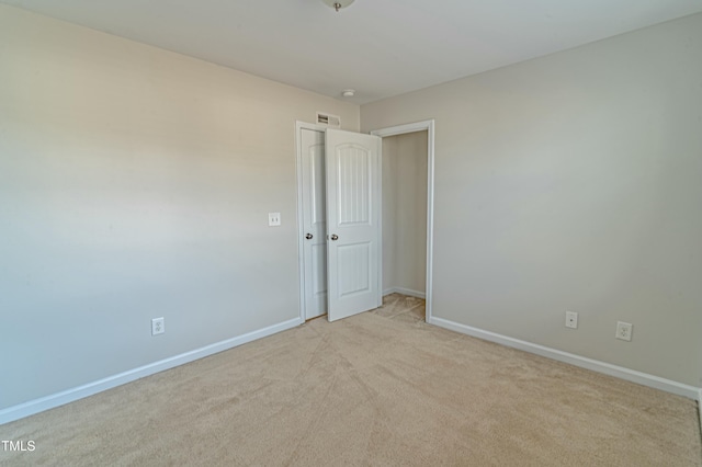 unfurnished room featuring light colored carpet