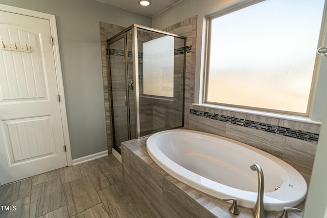 bathroom featuring a healthy amount of sunlight and shower with separate bathtub