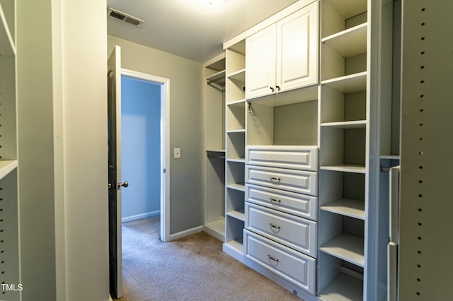 walk in closet featuring light colored carpet