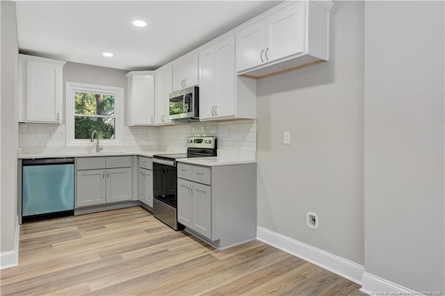 kitchen featuring decorative backsplash, sink, white cabinets, and appliances with stainless steel finishes