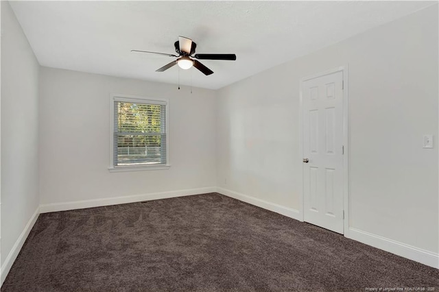 empty room featuring dark colored carpet and ceiling fan