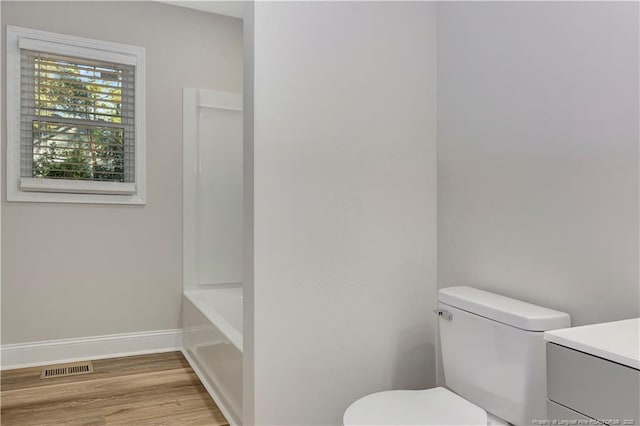 bathroom with vanity, a bathtub, toilet, and wood-type flooring