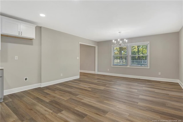 unfurnished dining area featuring dark hardwood / wood-style flooring and a notable chandelier