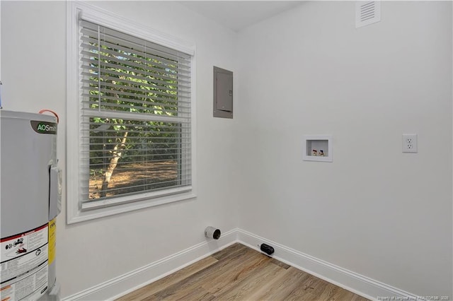 laundry room featuring washer hookup, electric panel, water heater, and light hardwood / wood-style flooring