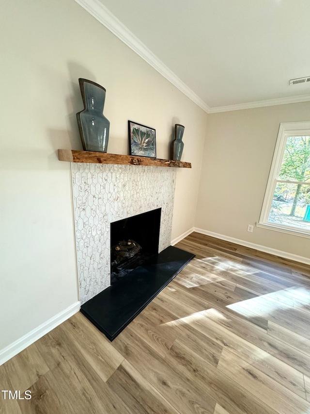 unfurnished living room with a fireplace, hardwood / wood-style flooring, and crown molding