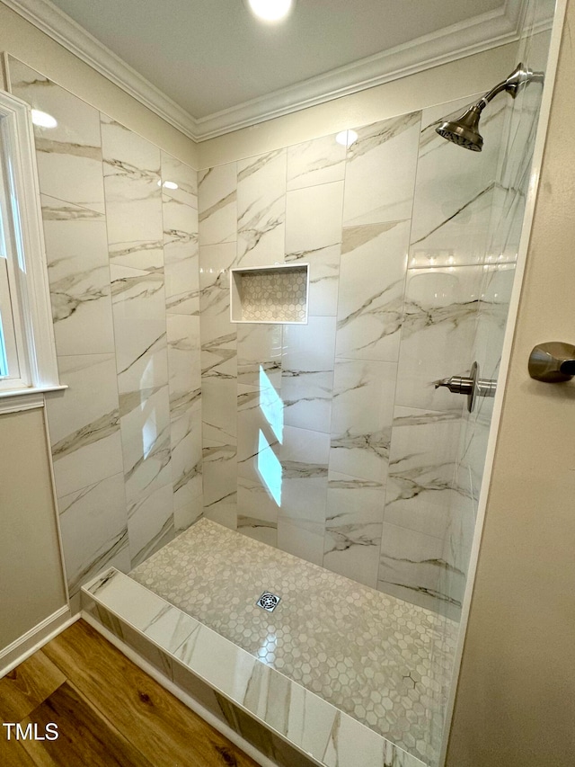 bathroom with a tile shower, ornamental molding, and hardwood / wood-style flooring