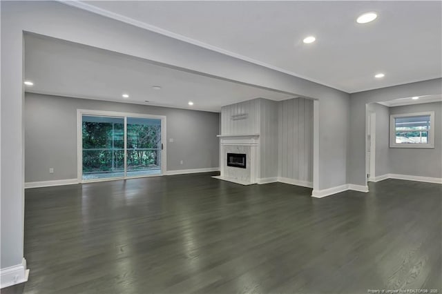 unfurnished living room featuring dark hardwood / wood-style floors and a high end fireplace