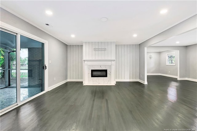 unfurnished living room with a healthy amount of sunlight, a premium fireplace, and dark wood-type flooring