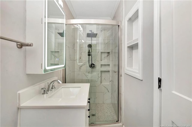 bathroom featuring vanity, an enclosed shower, and crown molding