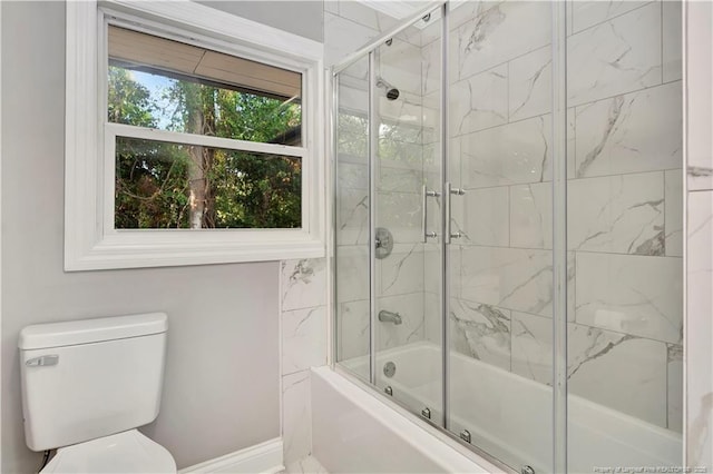 bathroom featuring bath / shower combo with glass door and toilet