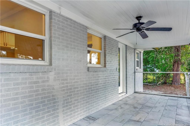 unfurnished sunroom featuring ceiling fan and wood ceiling