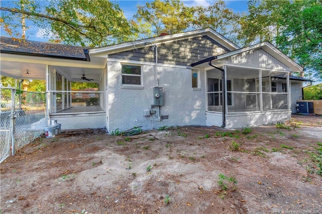 rear view of house featuring a sunroom and ceiling fan