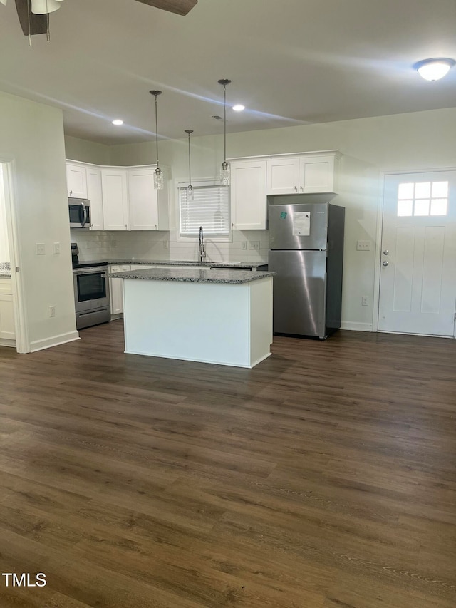 kitchen with white cabinetry, stainless steel appliances, dark hardwood / wood-style flooring, and decorative light fixtures