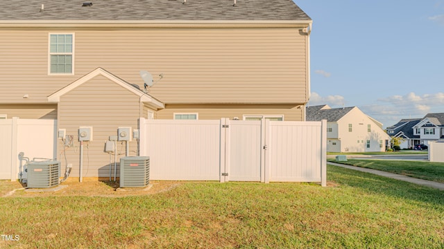 view of home's exterior with central air condition unit and a lawn