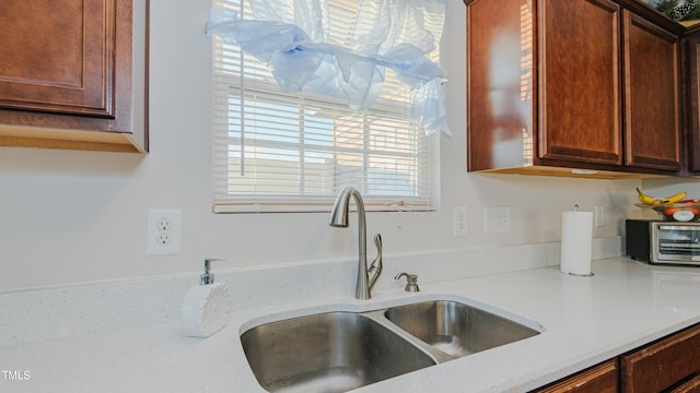 kitchen featuring light stone counters and sink