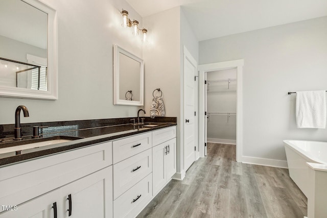 bathroom featuring vanity, hardwood / wood-style floors, and a tub