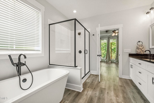 bathroom featuring wood-type flooring, ceiling fan, plus walk in shower, and vanity