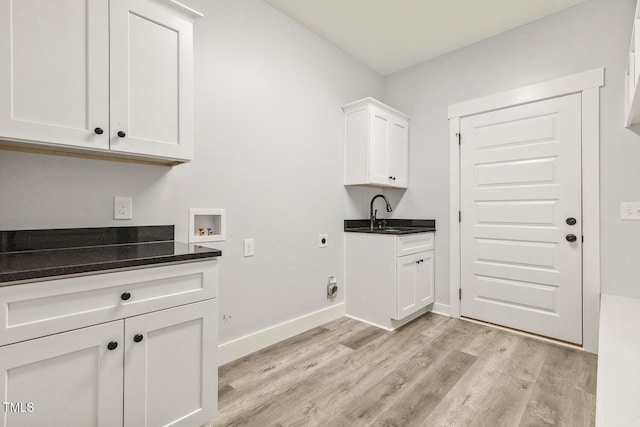 washroom featuring light hardwood / wood-style floors, electric dryer hookup, cabinets, sink, and washer hookup