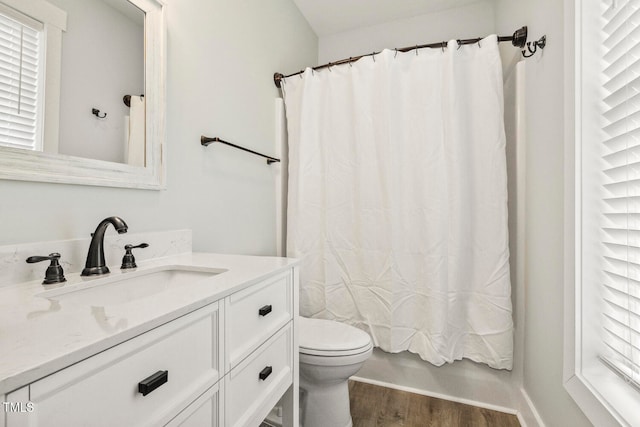 full bathroom featuring toilet, vanity, hardwood / wood-style flooring, and shower / bathtub combination with curtain