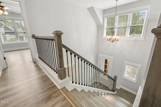 stairs with a chandelier and wood-type flooring