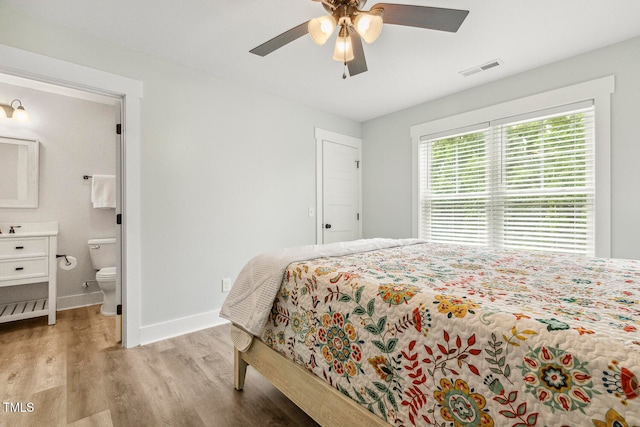 bedroom with ensuite bath, ceiling fan, and light hardwood / wood-style flooring