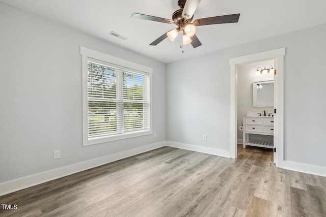 unfurnished bedroom with light hardwood / wood-style flooring, sink, ceiling fan, and ensuite bath