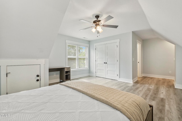 bedroom with ceiling fan, a closet, light hardwood / wood-style flooring, and vaulted ceiling