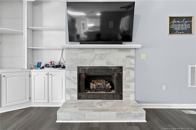 interior details with a tile fireplace and hardwood / wood-style floors