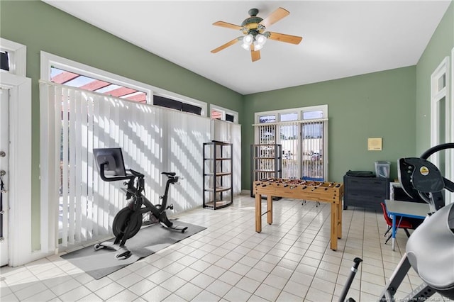 exercise room with ceiling fan and light tile patterned floors