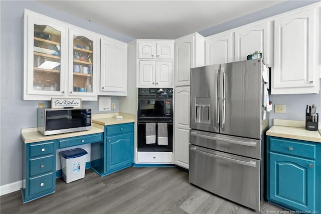 kitchen featuring appliances with stainless steel finishes, white cabinetry, blue cabinets, and light wood-type flooring