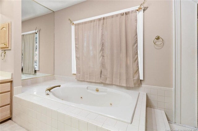 bathroom featuring vanity and tiled bath