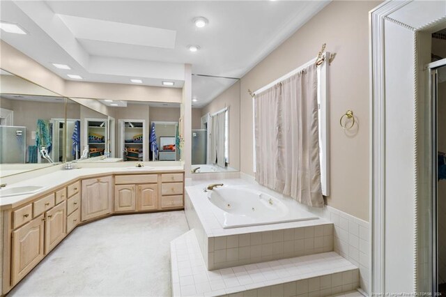 bathroom featuring vanity, independent shower and bath, and a skylight