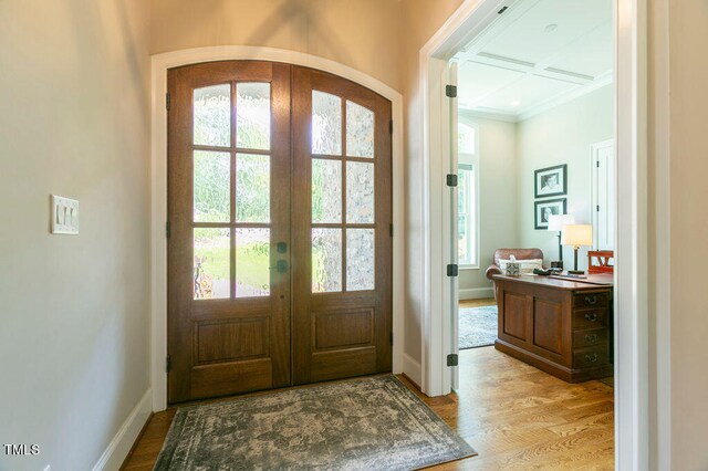 doorway with french doors, ornamental molding, light hardwood / wood-style flooring, and plenty of natural light