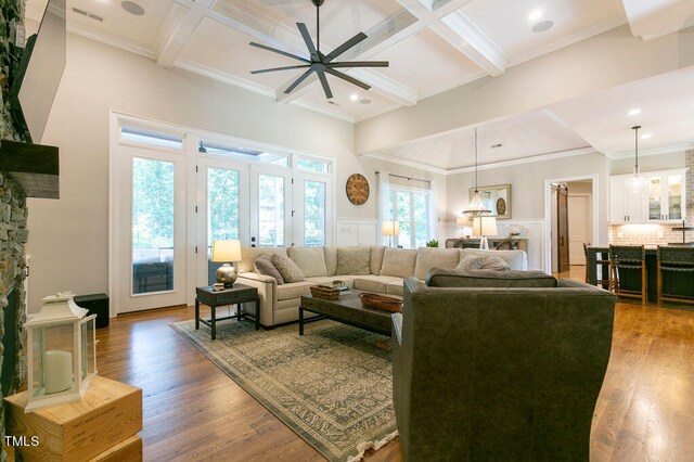 living room with crown molding, ceiling fan, coffered ceiling, beam ceiling, and hardwood / wood-style flooring