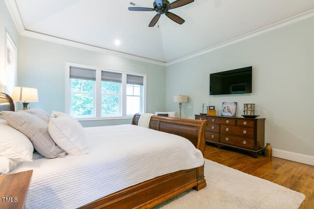 bedroom with ceiling fan, ornamental molding, vaulted ceiling, and dark hardwood / wood-style floors