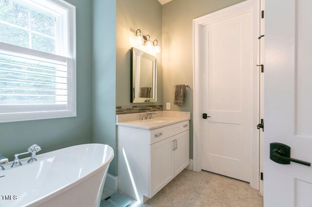 bathroom with vanity, a bathing tub, and plenty of natural light