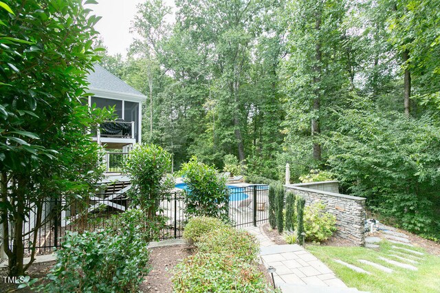 view of yard with a fenced in pool and a sunroom