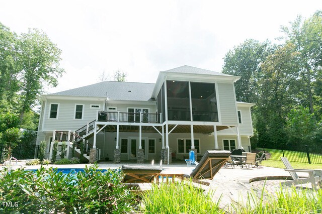 rear view of property featuring a pool side deck and a patio area