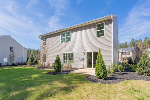 rear view of property with a yard and a patio area