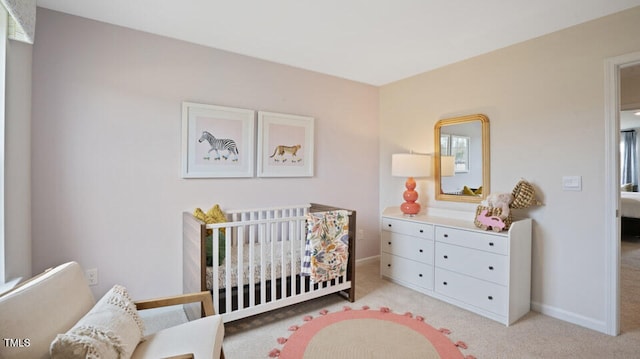 carpeted bedroom featuring a nursery area