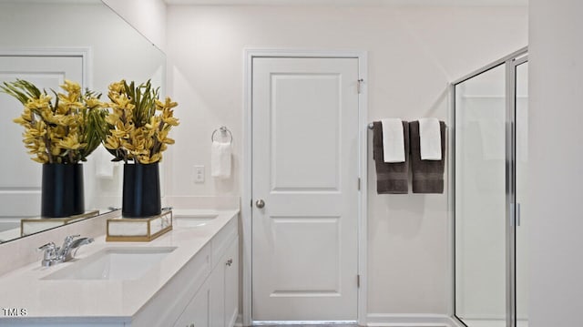 bathroom with vanity and a shower with door