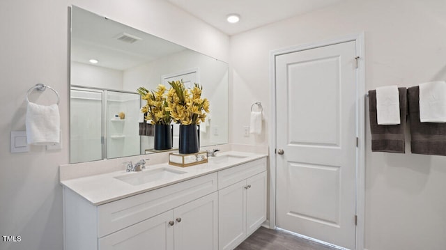 bathroom featuring vanity, an enclosed shower, and hardwood / wood-style flooring