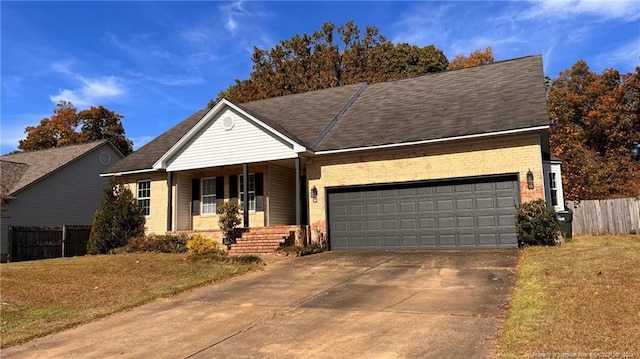 ranch-style home with covered porch, a front lawn, and a garage